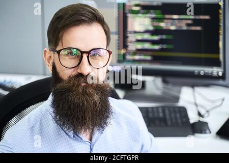 Closeup portrait of a serious computer programmer developer working in IT office, sitting at desk and coding a project in software development company Stock Photo
