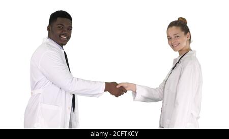Doctors shaking hands and posing to camera on white background. Stock Photo