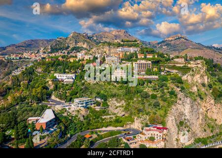 Taormina is a city on the island of Sicily, Italy. Mount Etna over Taormina cityscape, Messina, Sicily. View of Taormina located in Metropolitan City Stock Photo