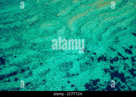 Sea surface aerial view. Background image of the turquoise sea. Deep sea and corals. Aerial drone shot of turquoise water, space for text. Aquamarine Stock Photo