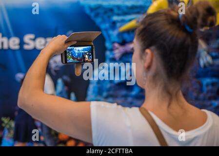 BANGKOK, THAILAND - DECEMBER 16, 2018 - Young Woman Taking Photo of Tales of the Sea Digital Theme Park Entrance on December 16, 2018 in Bangkok, Thai Stock Photo