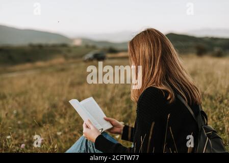 Young girl reading  a book in the nature Stock Photo