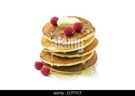 Stack of pancakes with butter, honey and raspberries on white Stock Photo
