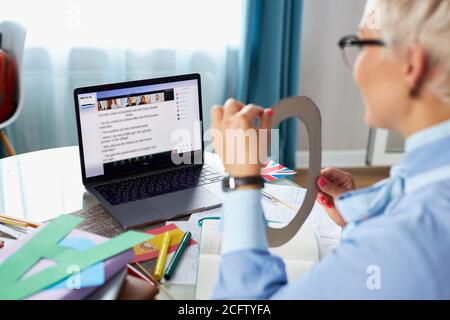 female teacher hold speech therapy session with students online, teaches pronunciation and language difficulties, using laptop Stock Photo