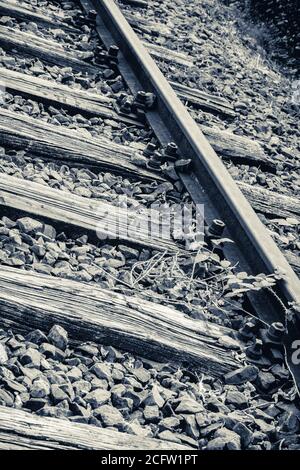 Vertical grayscale closeup shot of train tracks Stock Photo