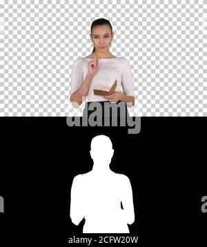 Young woman making notes while walking, Alpha Channel Stock Photo
