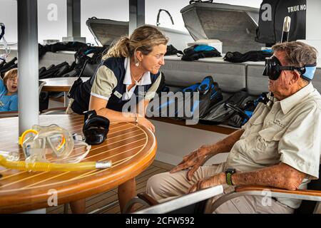 Nat has many tasks on board. Here she checks the selected diving goggles for the right fit. Fire and Dragons Cruise of the True North, Sunda Islands, Indonesia Stock Photo