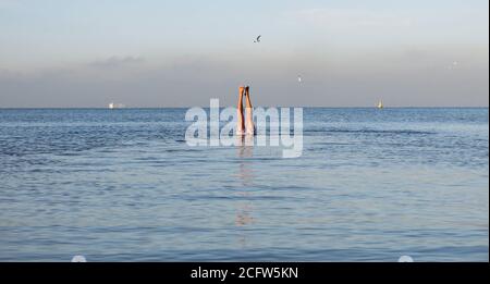 Melbourne Australia. Scenes of daily life in Melbourne Australia . Two feet  and a sea view, a man does a hand stand in Port Phillip Bay . Stock Photo