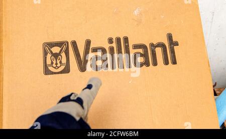 Paris, France - Aug 14, 2020: Installer hand pointing to Vaillant gas boiler heating system during installation Stock Photo