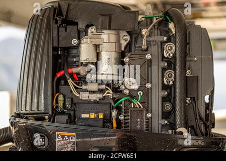 The open engine block of an outboard motor reveals wiring and components during maintenance on a tender of the True North off Flores, Indonesia. Stock Photo
