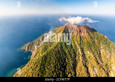 The smell of sulfur from the active Batu Tara volcano on the indonesian island of Pulau Komba can even be smelled in the helicopter Stock Photo