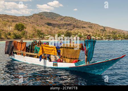 Indonesian sellers offer their textiles from boat, Sunda Islands, Indonesia Stock Photo