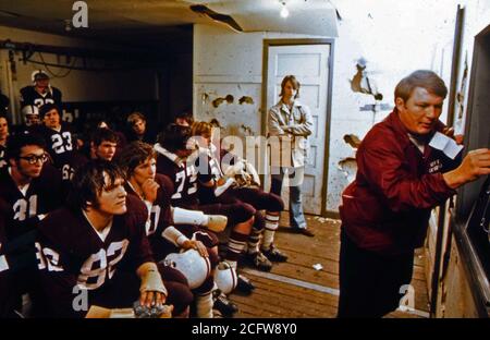 A high school football coach discusses strategy with his players before a Friday night game in New Ulm, Minnesota Stock Photo