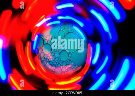 art photo of an abstract background of radial blue red and yellow stripes of light on a black background Stock Photo