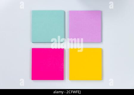 4 Color Sticky Note or Note Pad as Green,Purple,Pink,Yellow on Modern Clean Creative Office Desk or Office Table on Top View. Office Supplies on Blue Stock Photo