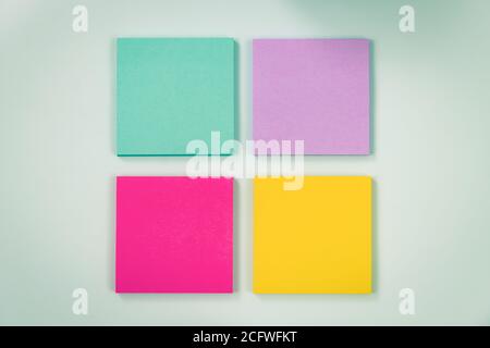 4 Color Sticky Note or Note Pad as Green,Purple,Pink,Yellow on Modern Clean Creative Office Desk or Office Table on Top View. Office Supplies on Blue Stock Photo