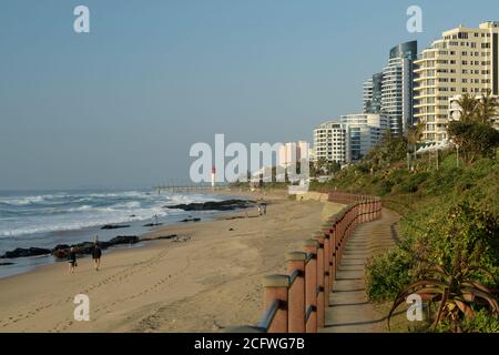 Beautiful landscape, people walking on Umhlanga Rocks beach, seaside, Durban, KwaZulu-Natal, South Africa, waterfront, blue sky, hotels, buildings Stock Photo