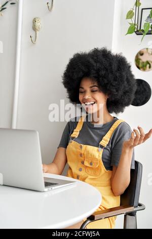Happy African lady using laptop video conference calling friend in cafe. Stock Photo