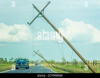 Drivers pass damaged power lines on Ward Line Road after Hurricane Laura, Sept. 6, 2020, in Bell City, Louisiana. Stock Photo