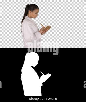 Successful medical doctors making notes while walking, Alpha Channel Stock Photo