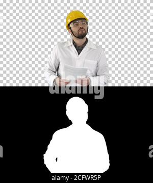 Site engineer cheching papers and something around him, Alpha Channel Stock Photo