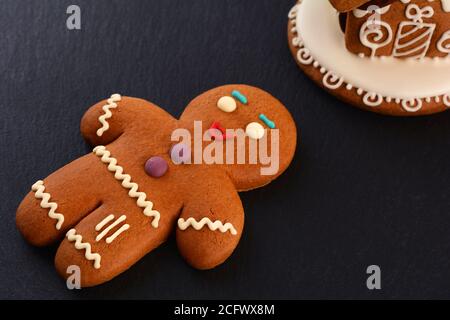 Gingerbread men and Gingerbread house on dark background. Christmas or New Year composition. Christmas card. Stock Photo