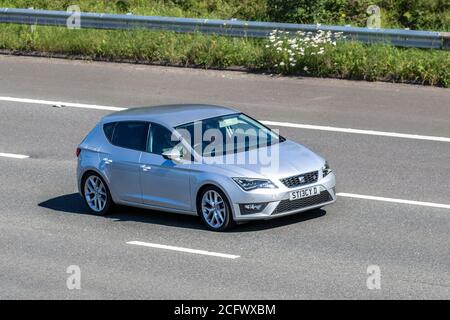 2014 silver SEAT Leon FR Technology TSI; Vehicular traffic moving vehicles, cars driving vehicle on UK roads, motors, motoring on the M6 motorway highway network. Stock Photo