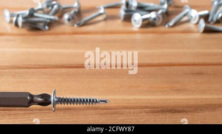 A screwdriver and self-cutters on a brown wooden background. Building tools to repair the house. Stock Photo