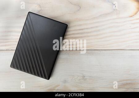 External compact SSD-drive for writing, reading and storing data on wood table background copy space Stock Photo