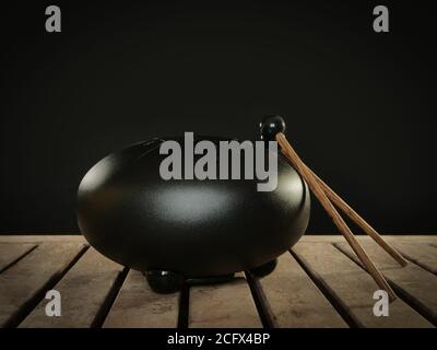 Steel tongue drum rare music playing instrument, made from propane tank and also known as tank drum or hank drum similar to Pantam.  On wooden surface Stock Photo