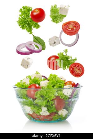 Falling vegetables in a salad bowl, white background Stock Photo