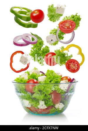 Falling vegetables in a salad bowl, white background Stock Photo