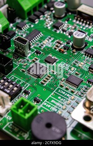 green circuitboard with microcontroller and lots of connectors and high density components Stock Photo