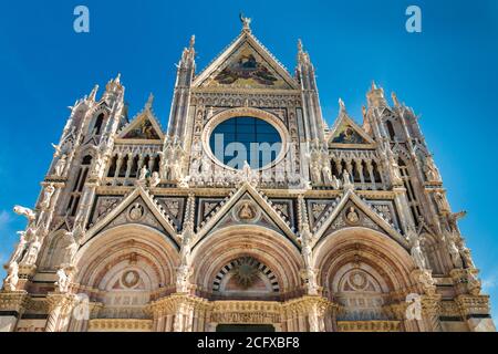 Perfect low-angle close-up shot of the west façade of the famous Duomo di Siena, a medieval cathedral in Siena, Italy. Built using polychrome marble,... Stock Photo