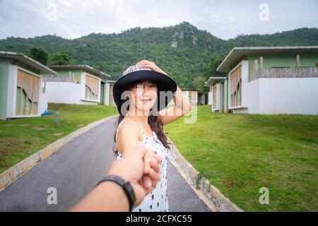 Couple traveling With focus on women Happy hand in hand The back is a mountain village view. Stock Photo
