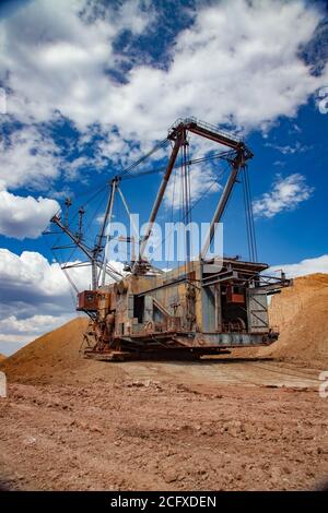 Walking dragline excavator in Bauxite clay quarry. Aluminium ore mining and transporting. Bauxite clay. Open-cut mining. Stock Photo