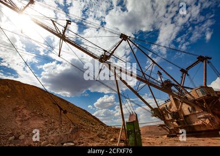 Aluminium ore quarry. Bauxite clay open-cut mining. Heavy quarry electrical walking dragline excavator. Mast and steel cables and electrical transform Stock Photo