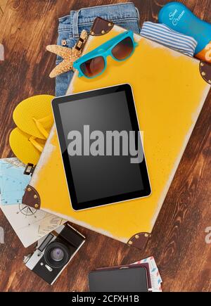 Digital tablet, suitcase, clothing and personal accessories Stock Photo