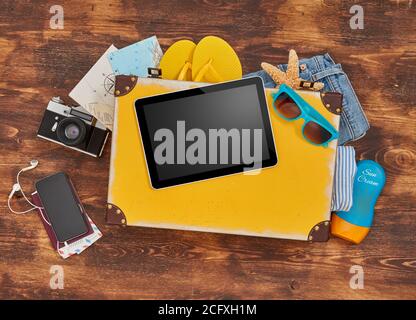 Digital tablet, suitcase, clothing and personal accessories Stock Photo