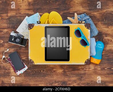 Digital tablet, suitcase, clothing and personal accessories Stock Photo
