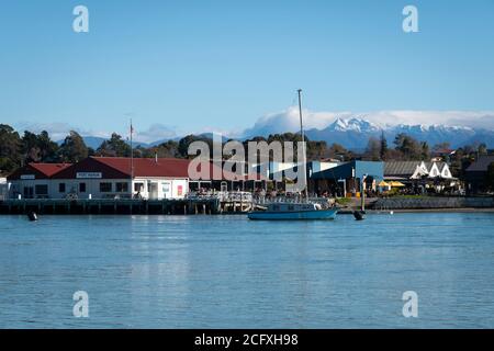 Boats and wharf at Mapua, Nelson, South Island, New Zealand.  Snow capped Mount Arthur Range in distance. Stock Photo