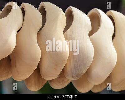 Row of blank new wooden Dutch clogs for sale on a market Stock Photo