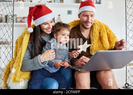 Family with child makes a video call or video chat at home for Christmas Stock Photo