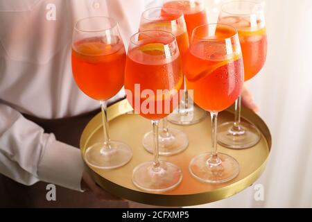 Waiter holding tray with aperol spritz cocktail. Summer drink Stock Photo