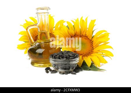 Sunflower, seeds and glass jug of oil isolated on white background Stock Photo