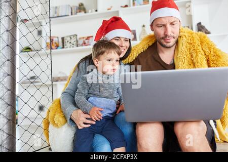 Family with child makes video chat over video call at Christmas in the living room Stock Photo