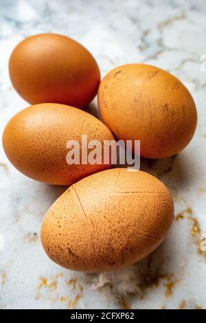 4 brown hen eggs closeup on a marble kitchen worksurface Stock Photo