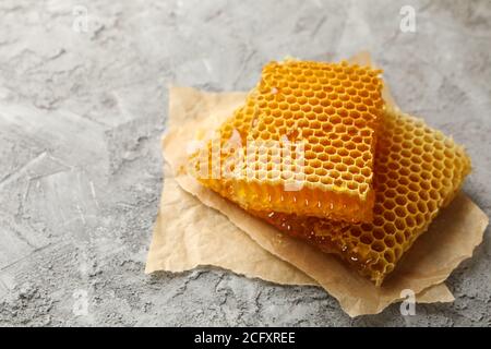 Baking paper with honeycomb pieces on gray background Stock Photo