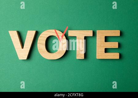 Word Vote made of wooden letters on green background Stock Photo