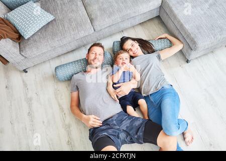 Portrait of happy family with child on the living room floor Stock Photo